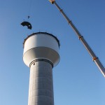 Crane Lifting Up a Piece of the Water Tower