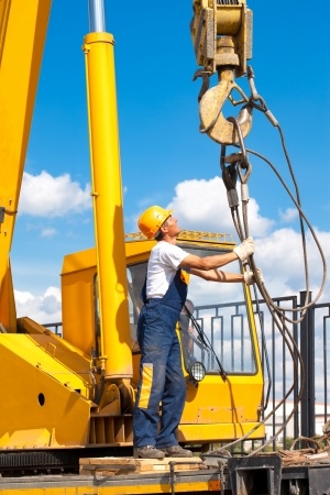 Worker making sure crane is safely working 