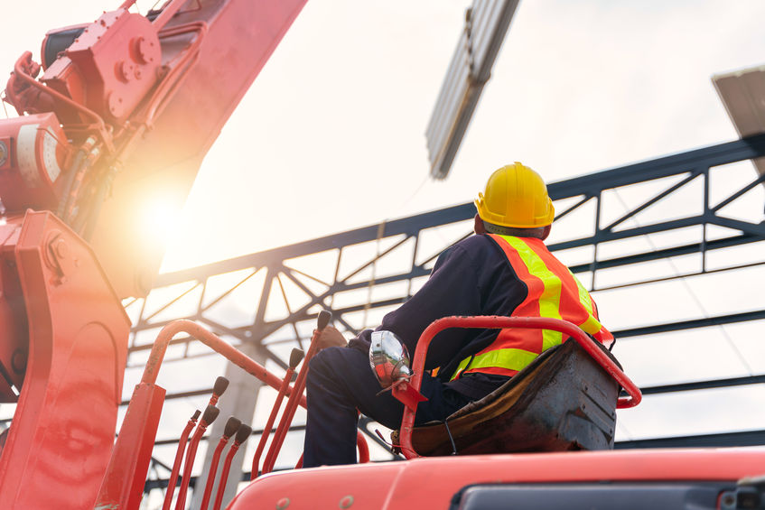 A crane driver is working on the construction site.