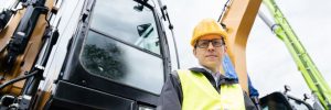Crane operator in a hardhat in a work vest at a jobsite