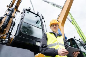 Crane operator in a hardhat in a work vest at a jobsite