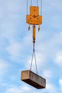 Crane lifting a concrete block